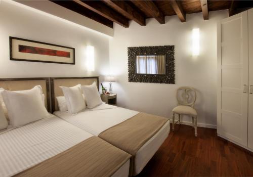 1 dormitorio con 2 camas y 1 silla en Apartamentos Abad Toledo, en Toledo