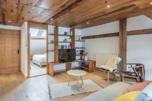 Il comprend un salon doté de plafonds en bois et une chambre. dans l'établissement Appartement Soffitta - Welkeys, à Chamonix-Mont-Blanc
