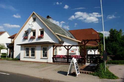 ein weißes Haus mit einem Schild davor in der Unterkunft Hotel am Gisselgrund in Frankenhain