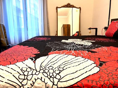 a bed with a red and white quilt on it at Minardi Apartments in Vercelli