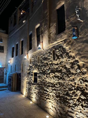 a stone building with lights on the side of it at Bait Baityn بيت البيتين in Misfāh