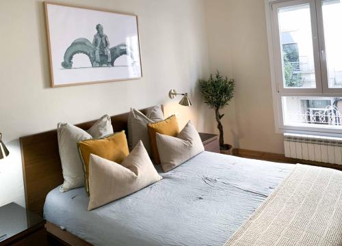 a bedroom with a large bed with many pillows at Hotel Celta in Vigo