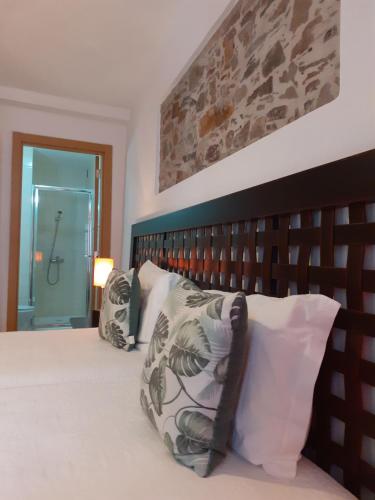 a bedroom with a large bed with a wooden headboard at Largo da Fonte in Sertã