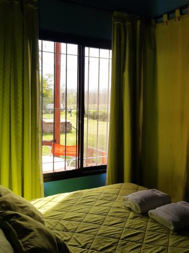 a bedroom with a bed and a large window at Cabañas Teoba in San José