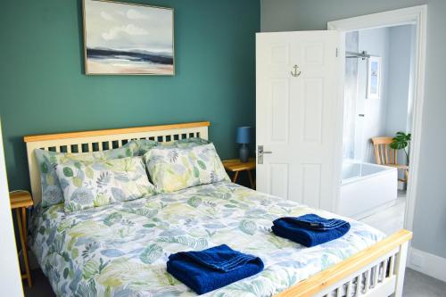 ein Schlafzimmer mit einem Bett mit zwei blauen Handtüchern darauf in der Unterkunft Curlew Cottage - Suffolk Coastal Escapes in Pakefield