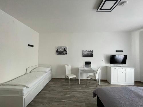 a bedroom with a bed and a desk and a tv at Nici´s Appartements Heidenreichstein in Heidenreichstein