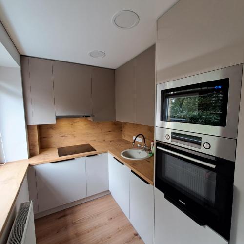 a small kitchen with a sink and a microwave at Vytės apartamentai in Kaunas