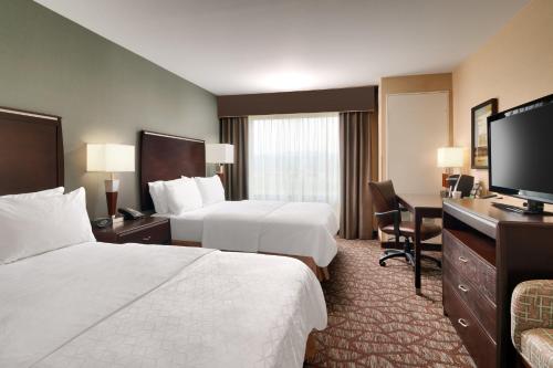 a hotel room with two beds and a flat screen tv at Holiday Inn Express Hotel & Suites Butte, an IHG Hotel in Butte