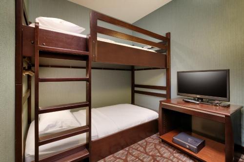 a room with two bunk beds and a television at Holiday Inn Express Hotel & Suites Butte by IHG in Butte