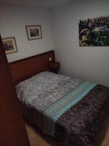 1 cama en un dormitorio con un cartel en la pared en Deux pièces avec grande terrasse au calme en Saint-Martin-Vésubie