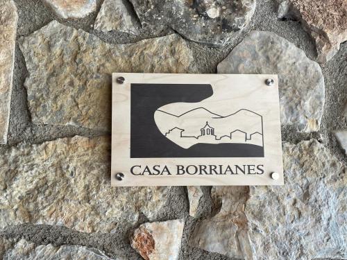 una señal en el costado de una pared de piedra en Prades Vila Bella - Casa Molinets i Casa Borrianes, en Prades