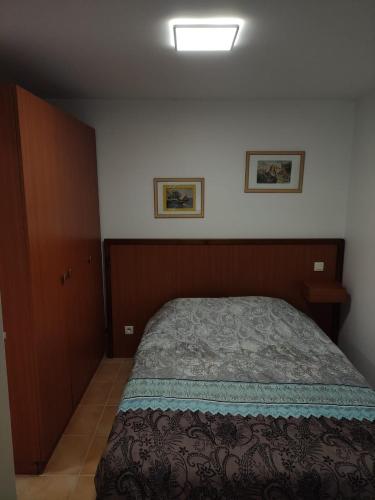 1 dormitorio con 1 cama y 2 cuadros en la pared en Deux pièces avec grande terrasse au calme en Saint-Martin-Vésubie