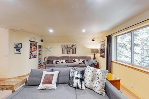 een woonkamer met een grijze bank en een raam bij Fawn Haven in Truckee