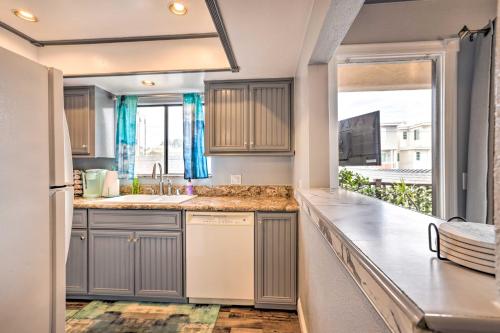 a kitchen with gray cabinets and a sink and a window at Pismo Beach Condo Less Than Walk to Beach and Wineries! in Pismo Beach
