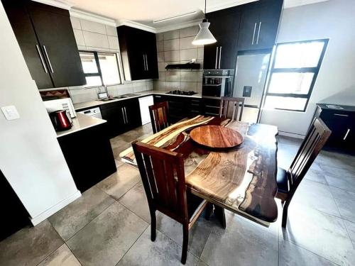 a kitchen with a wooden table and chairs in it at Bushveld Magic in Klipdrift