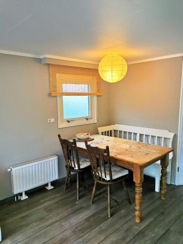 a dining room with a wooden table and chairs at Boslodge 84 in Vorden