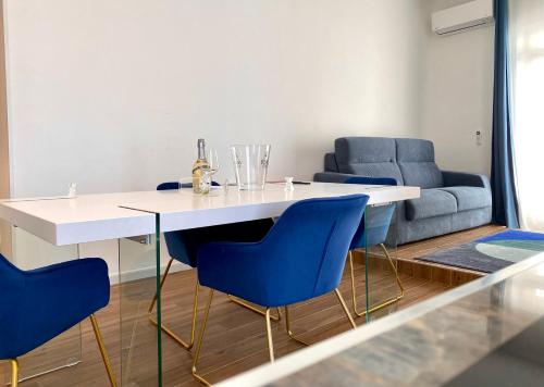 曼弗雷多尼亞的住宿－Roma Home -Manfredi Homes&Villas，一间配备有白色桌子和蓝色椅子的用餐室