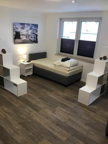 a bedroom with a bed and two white shelves at VerwöhnWohnungDeluxe in Wuppertal
