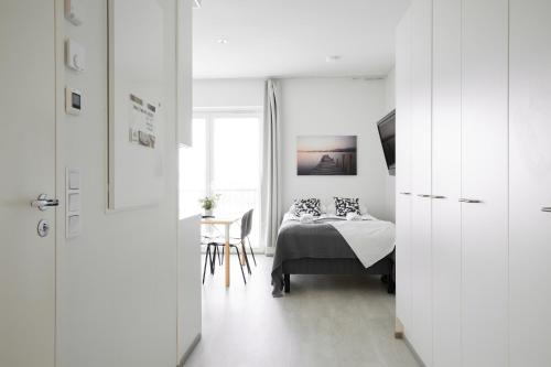 a bedroom with a bed and a table and a window at 7.kerroksen huoneisto, Wifi + 24/7 check in in Turku