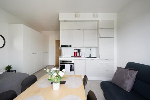 uma sala de estar com uma mesa e uma cozinha em 7.kerroksen huoneisto, Wifi + 24/7 check in em Turku