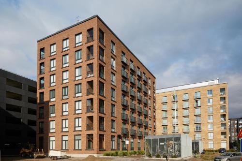 a tall brick building next to two other buildings at 7.kerroksen huoneisto, Wifi + 24/7 check in in Turku