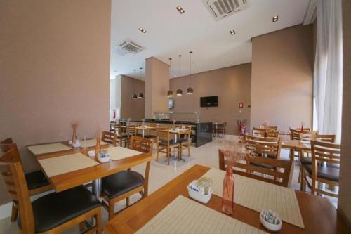 a dining room with wooden tables and chairs at Suíte & Flat Premium Rio Stay - Rio Centro in Rio de Janeiro