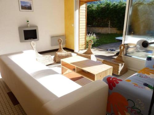 een woonkamer met een bank en stoelen en een tv bij Maison lumineuse et spacieuse avec terrain in La Bourboule