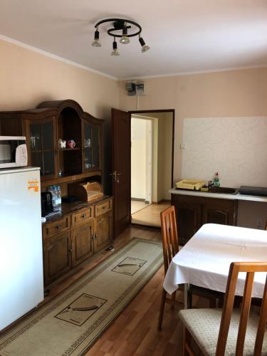 a kitchen with a white table and a refrigerator at Pensiunea Diskret in Sovata