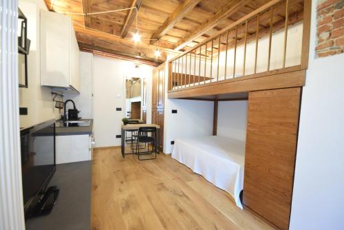 a loft bedroom with a bed and a kitchen at La dimora della Giudecca - 11 in Cuneo