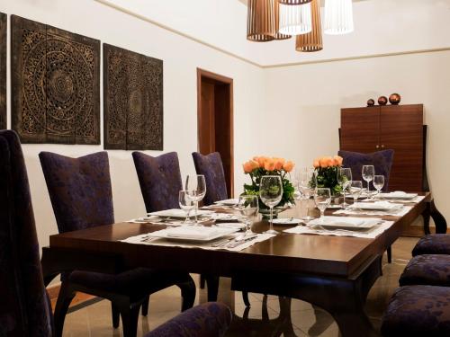 a dining room with a wooden table and blue chairs at Fiesta Americana Merida in Mérida