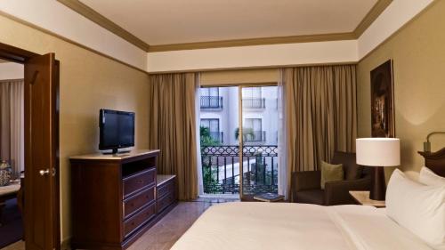 a hotel room with a bed and a television at Fiesta Americana Merida in Mérida