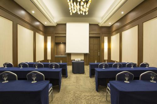 a conference room with blue tables and a white screen at Fiesta Americana Merida in Mérida