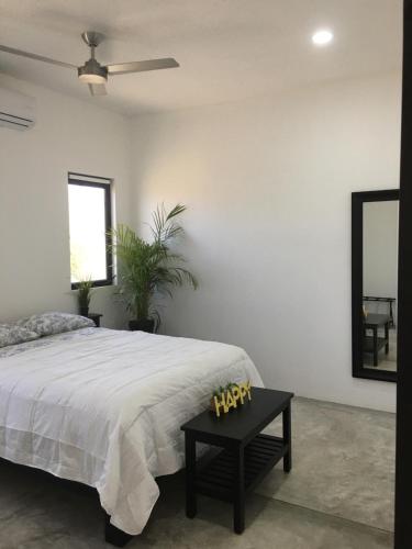 1 dormitorio con cama, mesa y espejo en Las Palmas Hotel - Cerritos Beach, en El Pescadero