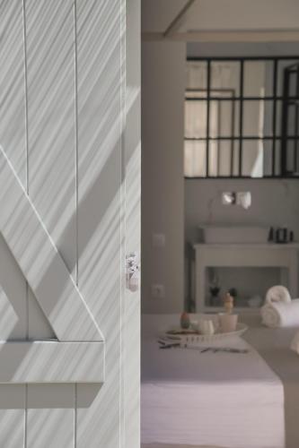 a white room with a staircase and a table at Korypho Villas in Barbati