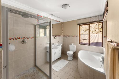 a bathroom with a tub and a toilet and a sink at Drakensberg Luxury Accommodation - Misty Ridge in Himeville