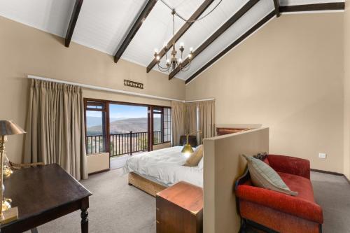 a bedroom with a bed and a desk and a chair at Drakensberg Luxury Accommodation - Misty Ridge in Himeville