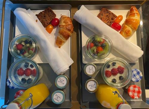a tray of food with different types of bread and fruit at Hotel Oudegracht in Utrecht