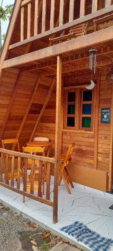 a wooden cabin with a table and chairs in it at CHALÉ HAKUNA MATATA-Vale do capão in Vale do Capao