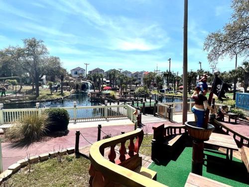 a family playing in a playground at a park at Walk to the Beach-Sleeps 10 and Golfcart in Myrtle Beach