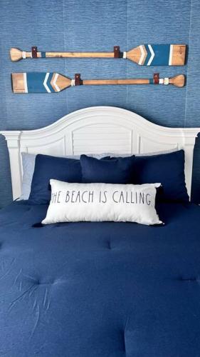 a bed with a pillow that says the beach is calling at Walk to the Beach-Sleeps 10 and Golfcart in Myrtle Beach
