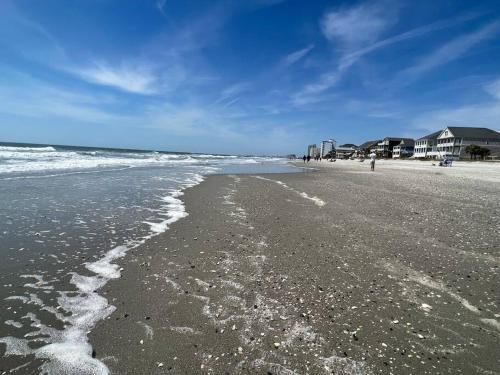 a beach with waves coming in from the ocean at Walk to the Beach-Sleeps 10 and Golfcart in Myrtle Beach
