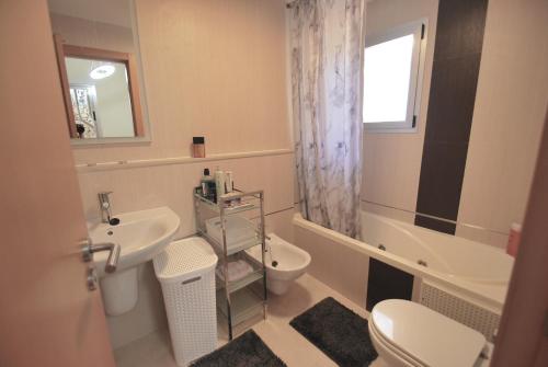 ein Badezimmer mit einem Waschbecken, einem WC und einem Spiegel in der Unterkunft Casalux One - Seaview - Outdoor Living - Pool - 5p in Pego