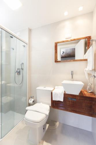 a bathroom with a toilet and a sink and a shower at Pousada Bora Bora in Bombinhas