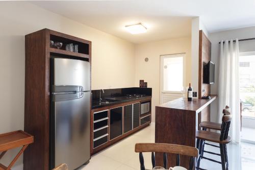 a kitchen with a stainless steel refrigerator and a counter at Pousada Bora Bora in Bombinhas