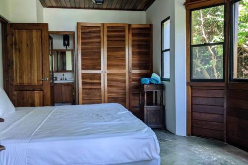 a bedroom with a large bed and a window at Shankton Harbour 3 Bedroom 4 Bathroom Beach House w Private BEACH SEA path in Tola