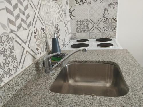 Una encimera de cocina con un fregadero y una estufa. en Las Amapolas Jujuy, en San Salvador de Jujuy