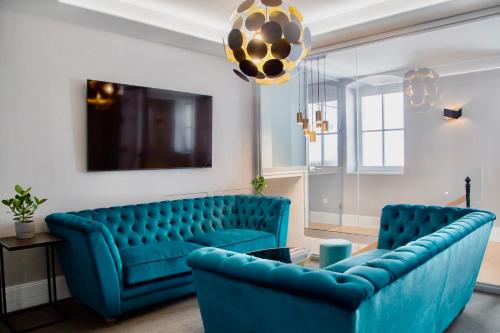 un soggiorno con divano blu e 2 sedie di Ibrahim Boutique Hotel a Kőszeg