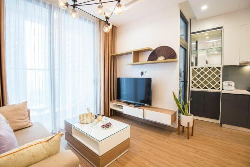 a living room with a couch and a tv at Sunny Vinhome Metropolis Apartment in Hanoi