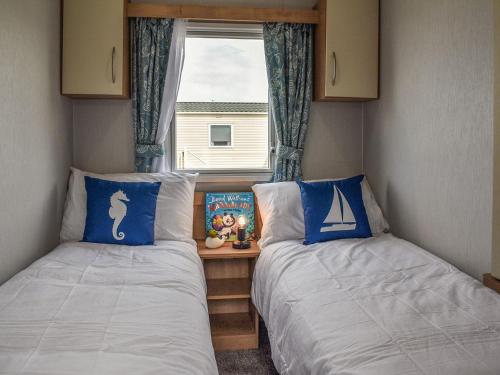 two beds in a small room with a window at Sea View Lodge in Heysham