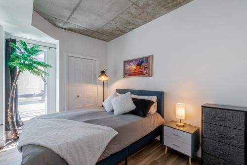 een slaapkamer met een bed en een palmboom erin bij 2 Bedroom condo - 800M of Old Quebec ! in Québec